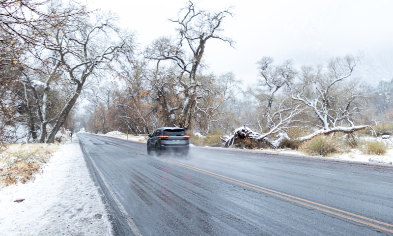 Car driving on a wet road in snowy winter weather